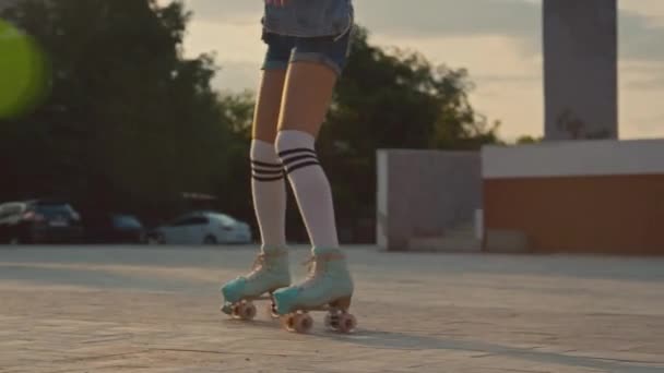 Döntetlen lövés boldog kaukázusi lány végző elemek görkorcsolya barátaival a parkban nappal - Felvétel, videó