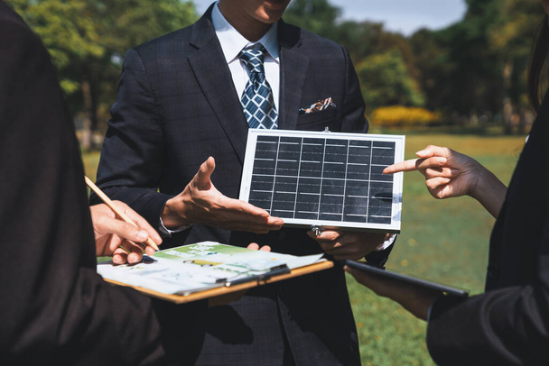 Réunion d'affaires en plein air sur l'énergie solaire, groupe de gens d'affaires travaillant et brainstorming sur l'utilisation des technologies d'énergie alternative comme engagement de l'entreprise à l'effort de RSE. Pneumatique - Photo, image