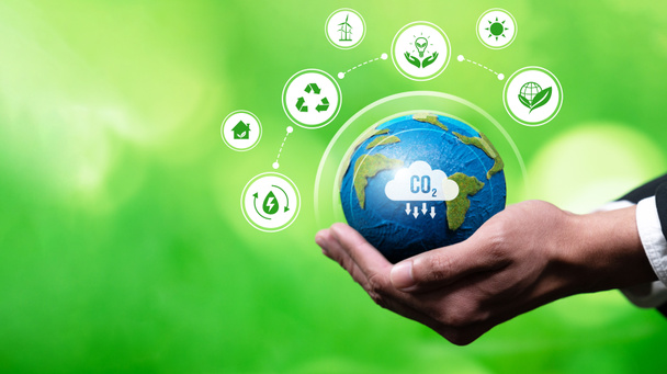 Επιχειρηματίες χέρι κρατώντας Γη σφαίρα συμβολίζουν την εταιρική δέσμευση για ESG ή ΕΚΕ για τη μείωση των εκπομπών άνθρακα και την υιοθέτηση φιλικών προς το περιβάλλον καθαρές επιχειρήσεις ελαχιστοποίηση των περιβαλλοντικών επιπτώσεων.Panorama Reliance - Φωτογραφία, εικόνα