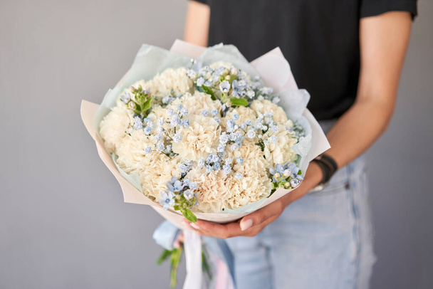 Small Beautiful bouquets of mixed flowers in woman hand. Floral shop concept . Beautiful fresh cut bouquet. Flowers delivery. High quality photo - Photo, Image