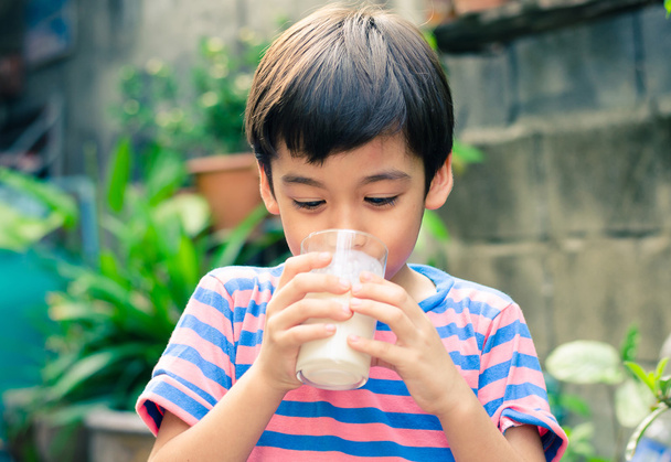 Kleiner Junge trinkt Milch im Park - Foto, Bild