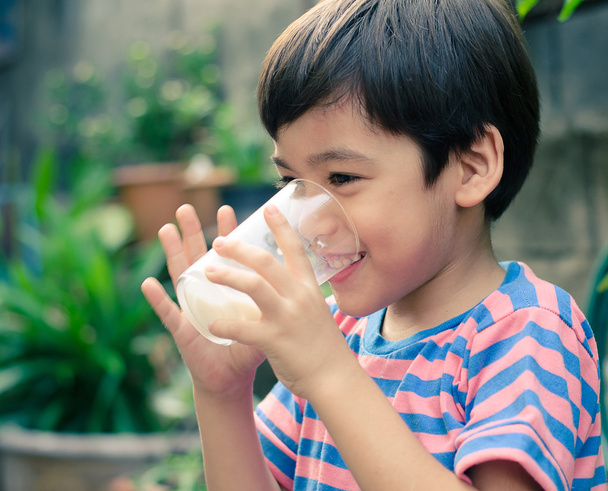 Kleiner Junge trinkt Milch im Vintage-Stil des Parks - Foto, Bild