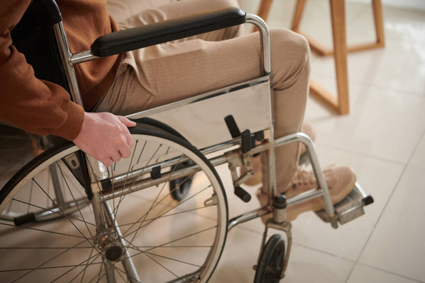 Genç adam ciddi bir trafik kazası geçirdikten sonra tekerlekli sandalye öğreniyor. - Fotoğraf, Görsel