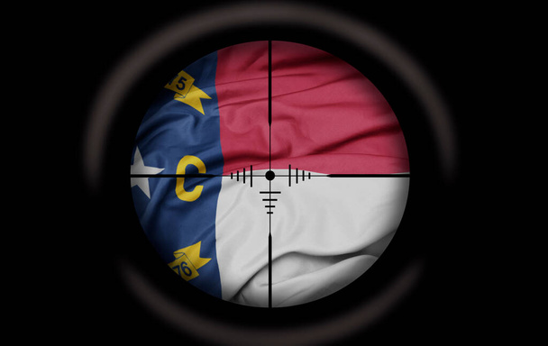 Снайперский прицел нацелен на большой красочный флаг штата Северная Каролина. концепция - Фото, изображение
