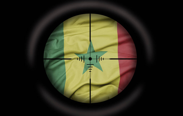 Снайперский прицел нацелен на большой красочный флаг Сенегала. концепция - Фото, изображение
