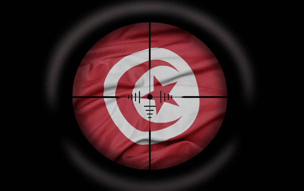 Снайперский прицел нацелен на большой красочный флаг тунисской страны. концепция - Фото, изображение
