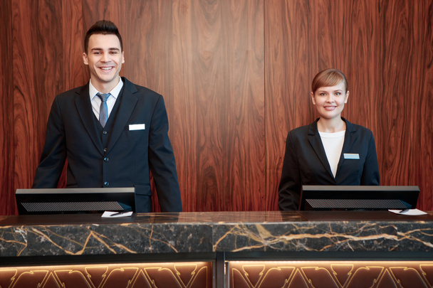 Hotel receptionists behind the counter - Φωτογραφία, εικόνα