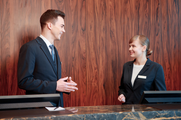 Hotel receptionists behind the counter - 写真・画像