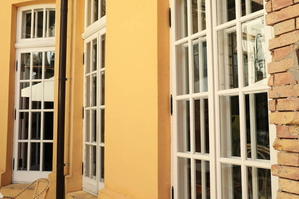 Gelbe Wand und Fenster an der Fassade des Cafés, im Freien - Foto, Bild