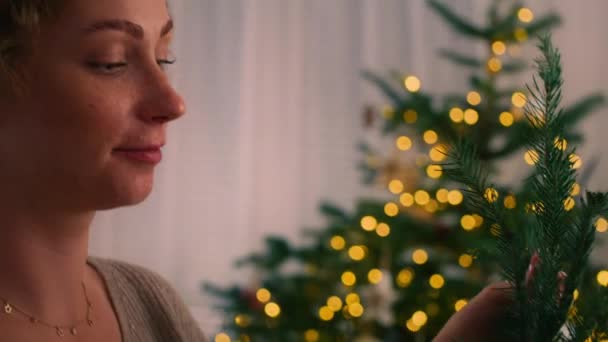 Młoda biała kobieta robi świąteczny wieniec. Nakręcony aparatem hel RED w rozdzielczości 8K.  - Materiał filmowy, wideo
