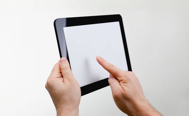Man hoding zwarte tablet frame in de hand geïsoleerd op witte close-up. Kan een beeld invoegen van uw tekst voor het concept of project ontwikkeling van mobiele toepassingen, hun reclame voor mobiele apparaten - Foto, afbeelding