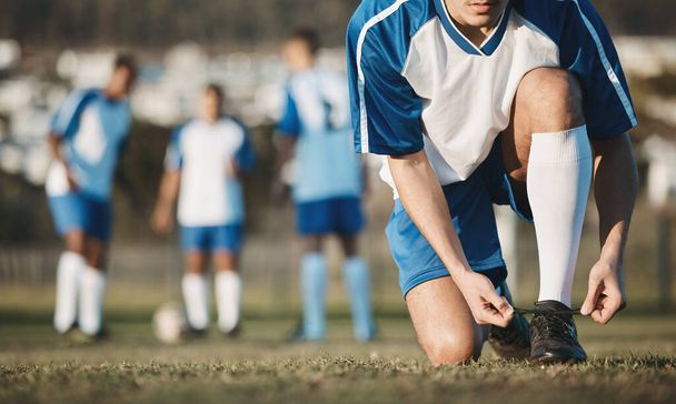 Tie, man or soccer player with shoes on football field in training, exercise or workout in Brazil. Lace, stadium or hands of athlete ready to start fitness match or sports game with boots or footwear. - Photo, Image