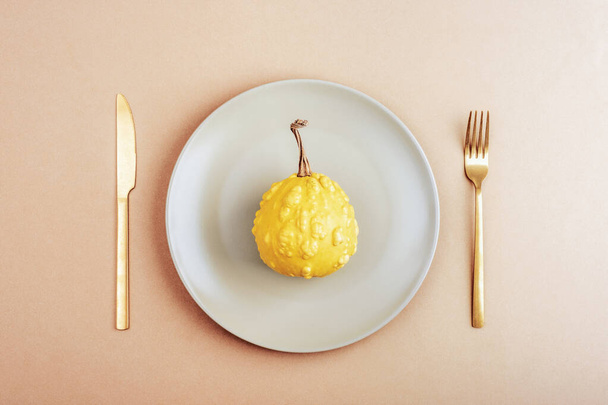 Autumn table place setting with grey plate with pumpkin on neutral background. Thanksgiving, halloween decoration. Top view, flat lay. - Photo, Image