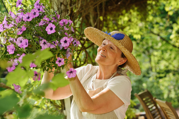 senior woman tends flowers - Photo, Image