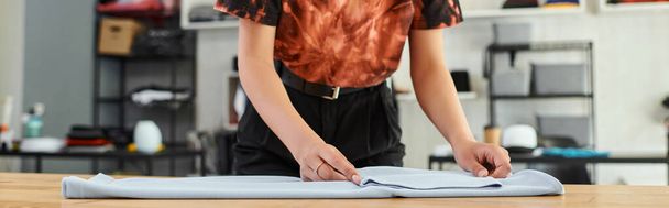 corte vista de qualificado asiático mulher dobrar roupas no têxtil impressão oficina, horizontal banner - Foto, Imagem