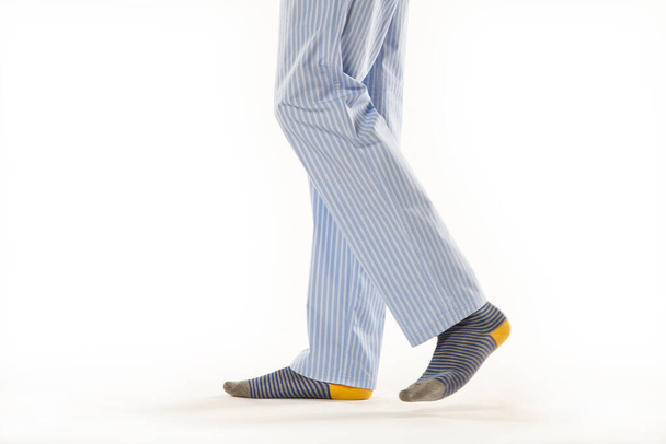 Pijama giyen bir adam. Beyaz arkaplan üzerine bacaklar ayrıntısı - Fotoğraf, Görsel
