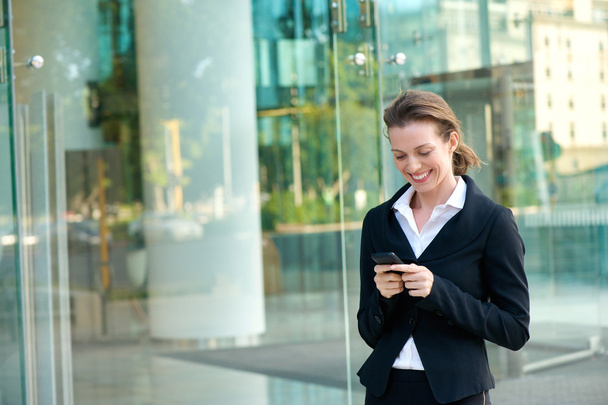 glückliche Geschäftsfrau liest SMS auf Handy  - Foto, Bild