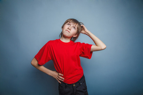 Niño, adolescente, doce años en camisa roja, pensativo, derzhet h
 - Foto, Imagen