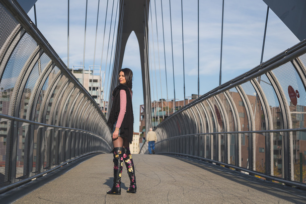 Beautiful young brunette posing on a bridge - Foto, imagen