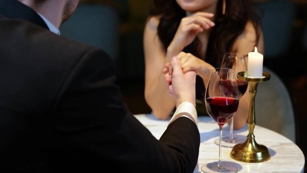 Genç ve mutlu bir kadın, erkek arkadaşıyla restoranda romantik bir buluşmada eğleniyor. Yaşam tarzı, aşk, ilişkiler. Yavaş çekim - Fotoğraf, Görsel