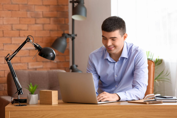 Jovem empresário com laptop trabalhando no escritório
 - Foto, Imagem