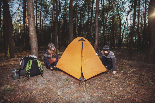 Couple of hikers setting a tent in the wood - Foto, Imagen