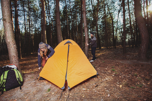 Couple of hikers setting a tent in the wood - Zdjęcie, obraz