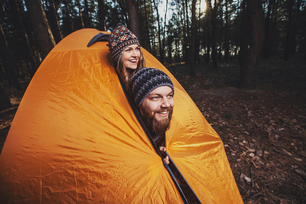 Couple of hikers setting a tent in the wood - Foto, imagen