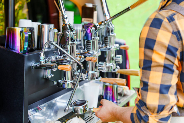 Barista robi smaczną kawę na profesjonalnej maszynie zainstalowanej w tylnej części minivana: Food Service, Najlepsza kawa i wydarzenia na świeżym powietrzu - Zdjęcie, obraz