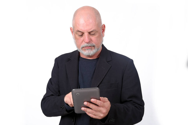 hombre adulto utilizando SeniorLife tableta portátil teléfono celular tecnología de comunicación - Foto, imagen
