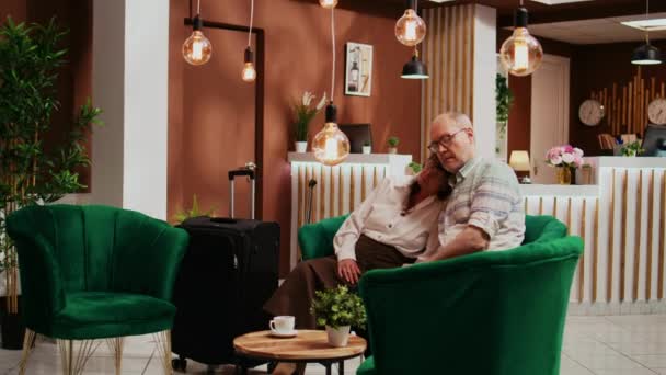 Rentnerpaar übernachtet in Hotellobby, wartet auf Zimmerreservierung und Urlaubsreise. Ältere Erschöpfte nach internationalem Flug mit Jetlag zu kämpfen, Tourismusbranche. - Filmmaterial, Video