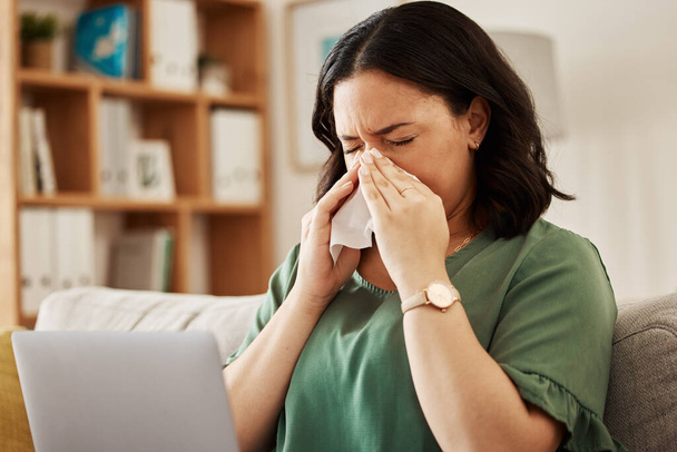 Remote work, laptop and sick woman on a sofa with flu, cold or viral infection in her house. Freelance, sneeze and lady online with allergies, virus or burnout, sinusitis or hayfever while working. - Photo, Image