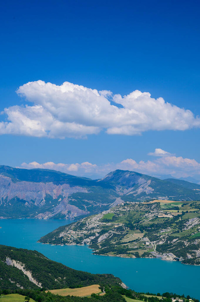 Widok z powietrza na błękitne jezioro Serre-Poncon, granica zbiornika wodnego między departamentami Hautes-Alpes i Alpes-de-Haute Provence, jeden z największych w Europie Zachodniej - Zdjęcie, obraz