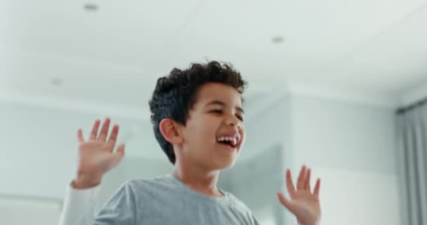 Kid, boy and jumping on bed in home while playing funny games with energy, freedom and laughing. Face of excited, happy and active young child bounce in air on furniture in house for movement of joy. - Footage, Video