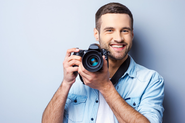 Young man holding digital camera - Фото, изображение