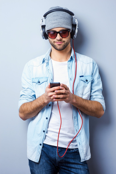 Stylish man in headphones holding MP3 - Photo, Image