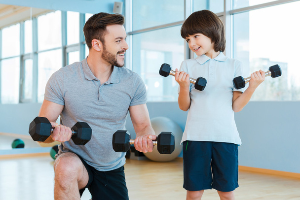 Father and son exercising with dumbbells - Φωτογραφία, εικόνα