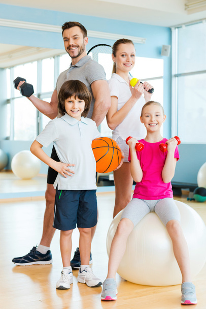 Family holding different sports equipment - Foto, afbeelding