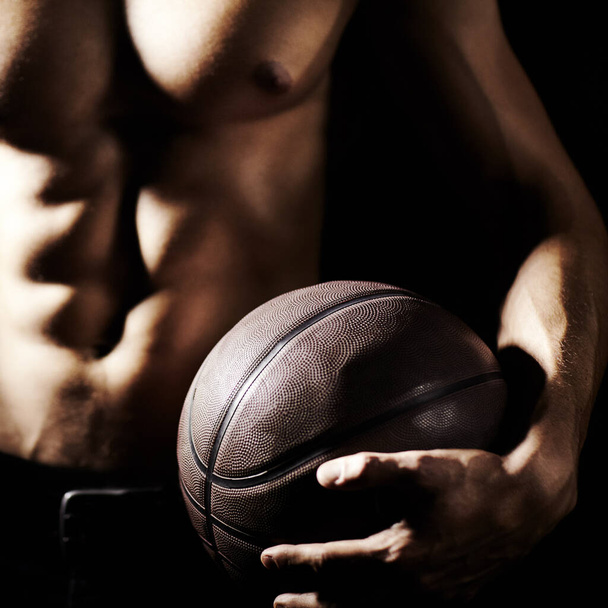 Μύες, σώμα και χέρια αθλητή με μπάσκετ σε στούντιο απομονωμένο σε μαύρο φόντο. Αθλητισμός, κοντινό πλάνο και δυνατός άνδρας με μπάλα, κοιλιακούς και προπόνηση για φυσική κατάσταση, προπόνηση ή άσκηση για την υγεία. - Φωτογραφία, εικόνα