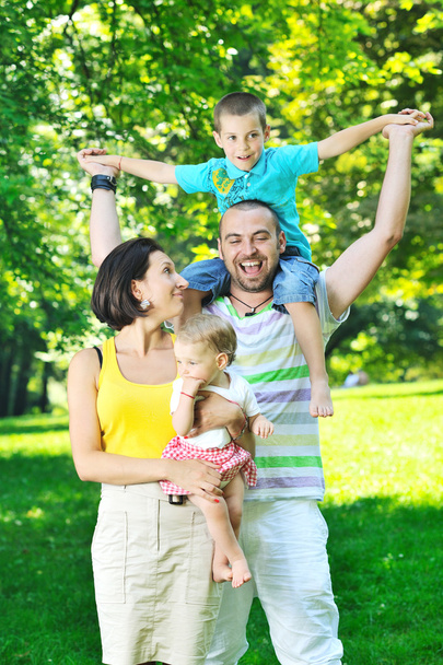 Onnellinen nuori pari lastensa kanssa pitää hauskaa puistossa
 - Valokuva, kuva