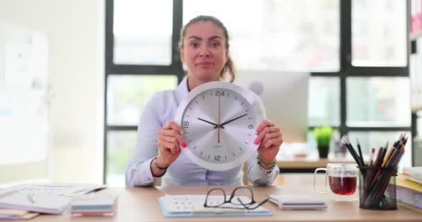 Businesswoman in office holding stylish wall clock. Overtime deadline and business woman - Footage, Video