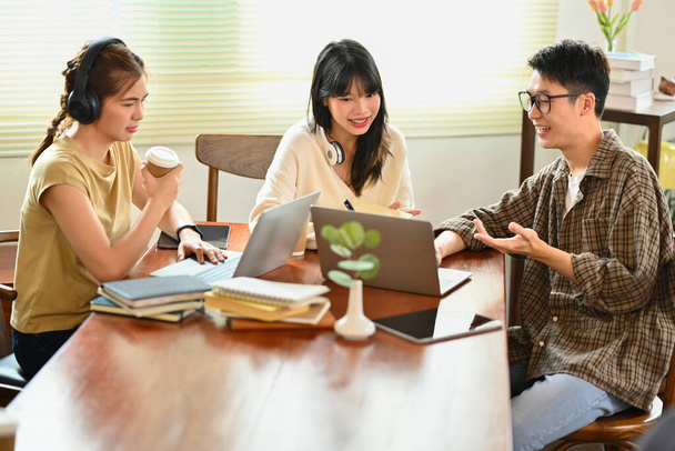 Grupo de jóvenes empresarios de startups que utilizan ordenador portátil y discuten ideas en el espacio de co-trabajo. - Foto, Imagen