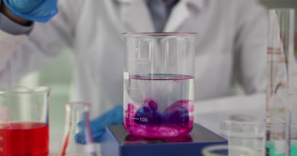 Closeup of scientist dripping purple liquid into flask with solvent. Research of toxic liquids - Footage, Video