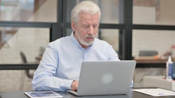 Vieux homme d'affaires avec mal de dents travaillant sur ordinateur portable dans le bureau - Séquence, vidéo