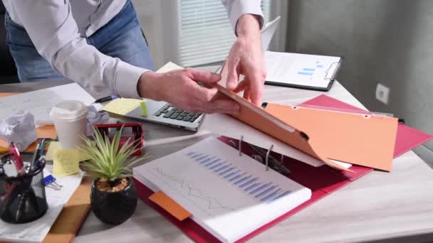 Neorganizovaný podnikatel pracující a hledající něco na špinavém stole v kanceláři - Záběry, video
