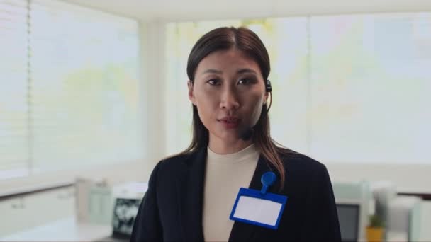 Plan moyen d'une femme d'affaires élégante portant un casque et parlant à la caméra au bureau - Séquence, vidéo