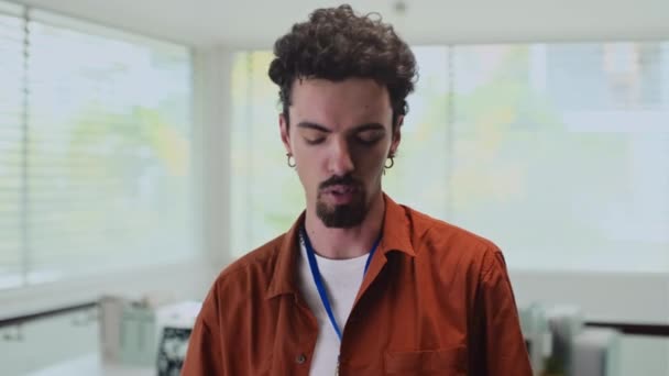 Medium shot van jonge mannelijke ondernemer opnemen van zichzelf en praten met camera van kantoor - Video