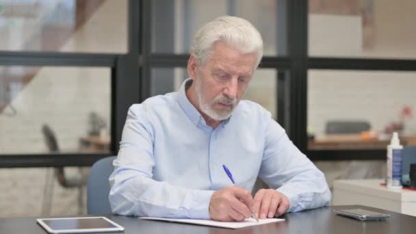 Gefrustreerde oude zakenman probeert een brief in kantoor te schrijven - Video
