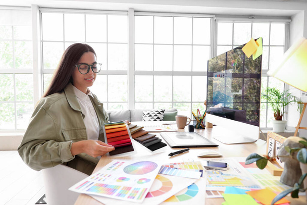 Designer de interiores feminino trabalhando com amostras de tecido na mesa no escritório - Foto, Imagem