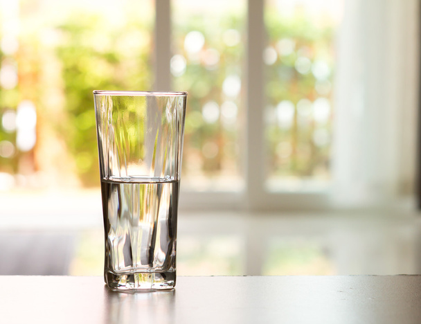 Closeup glas water op tafel in de woonkamer - Foto, afbeelding